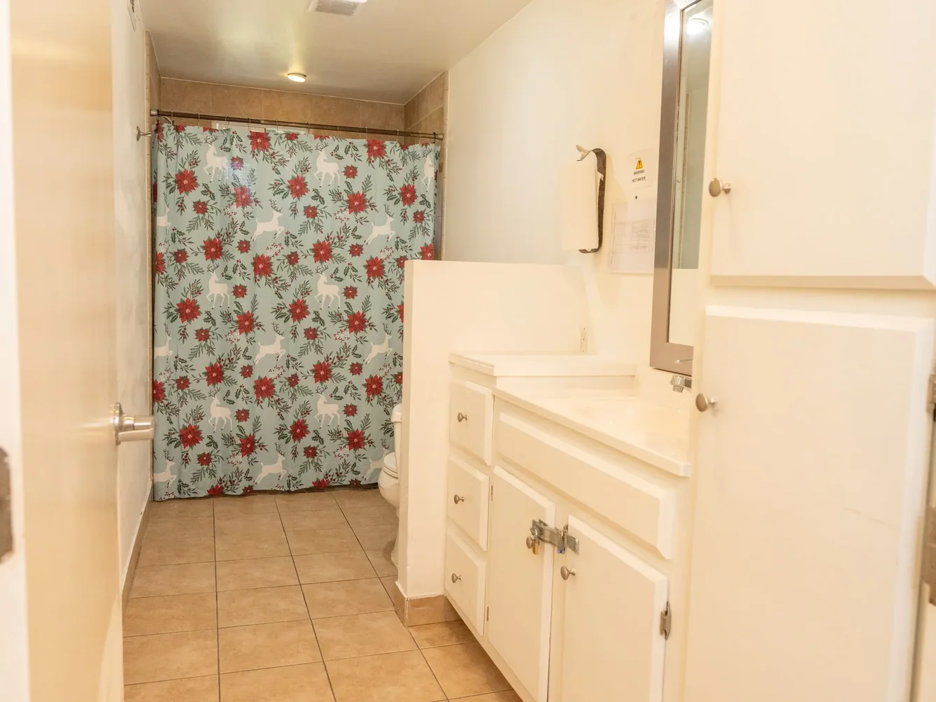 Clean accessible bathroom featuring white cabinetry, grab bars, and tile flooring