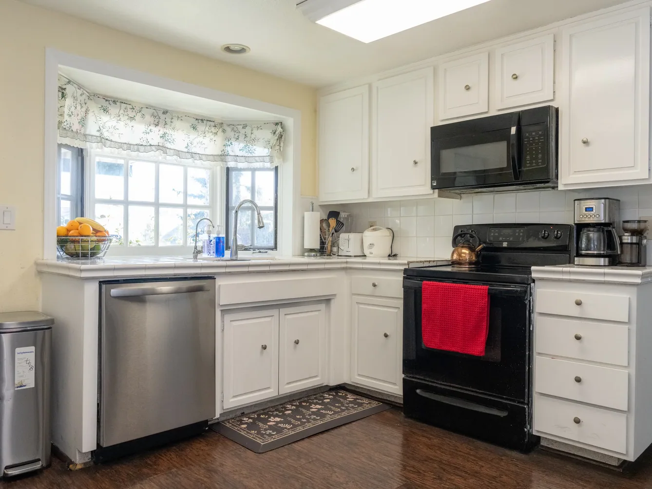 Accessible kitchen with white cabinetry, modern appliances, and bright natural lighting