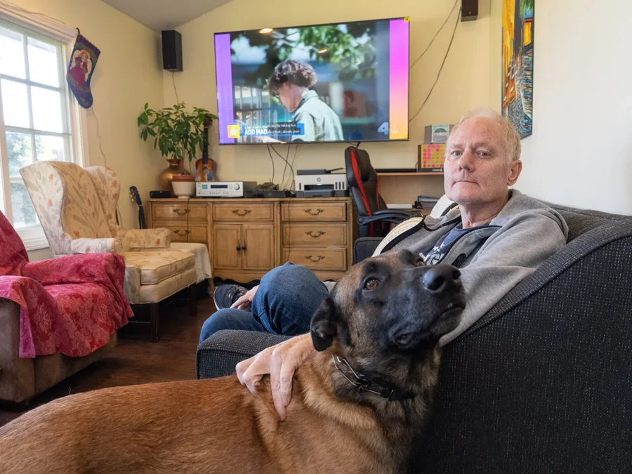 Resident relaxing at home with therapy dog on couch in comfortable living room setting